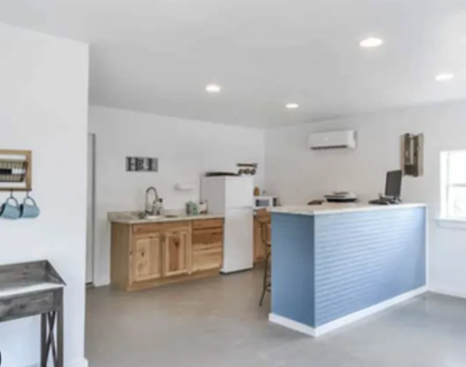 Interior of the office with a service counter, kitchenette, and air conditioning