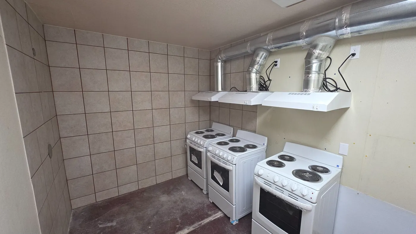 Shared kitchen with ranges and shelving at Windmill RV Park