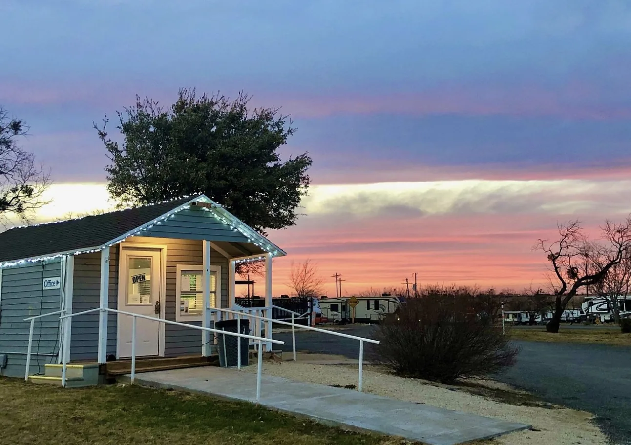 Tye RV Park office building at sunset with string lights along the porch roof